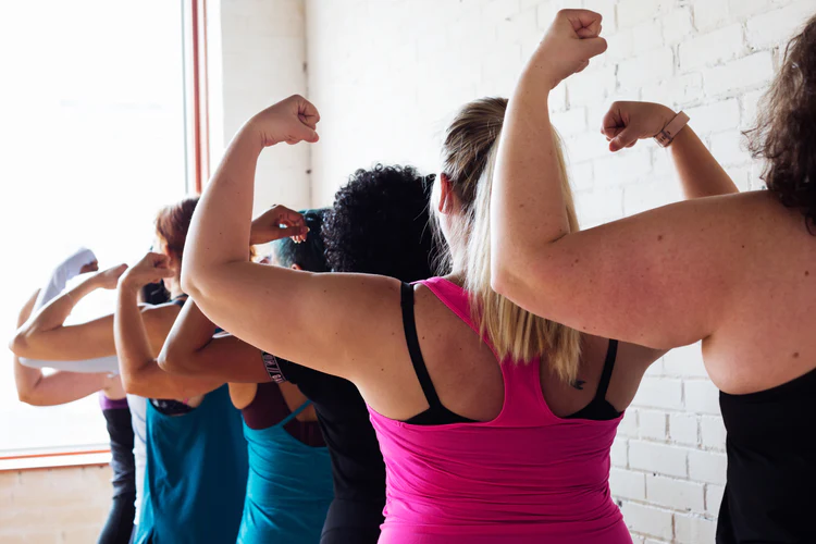 a group of women flexing their arms