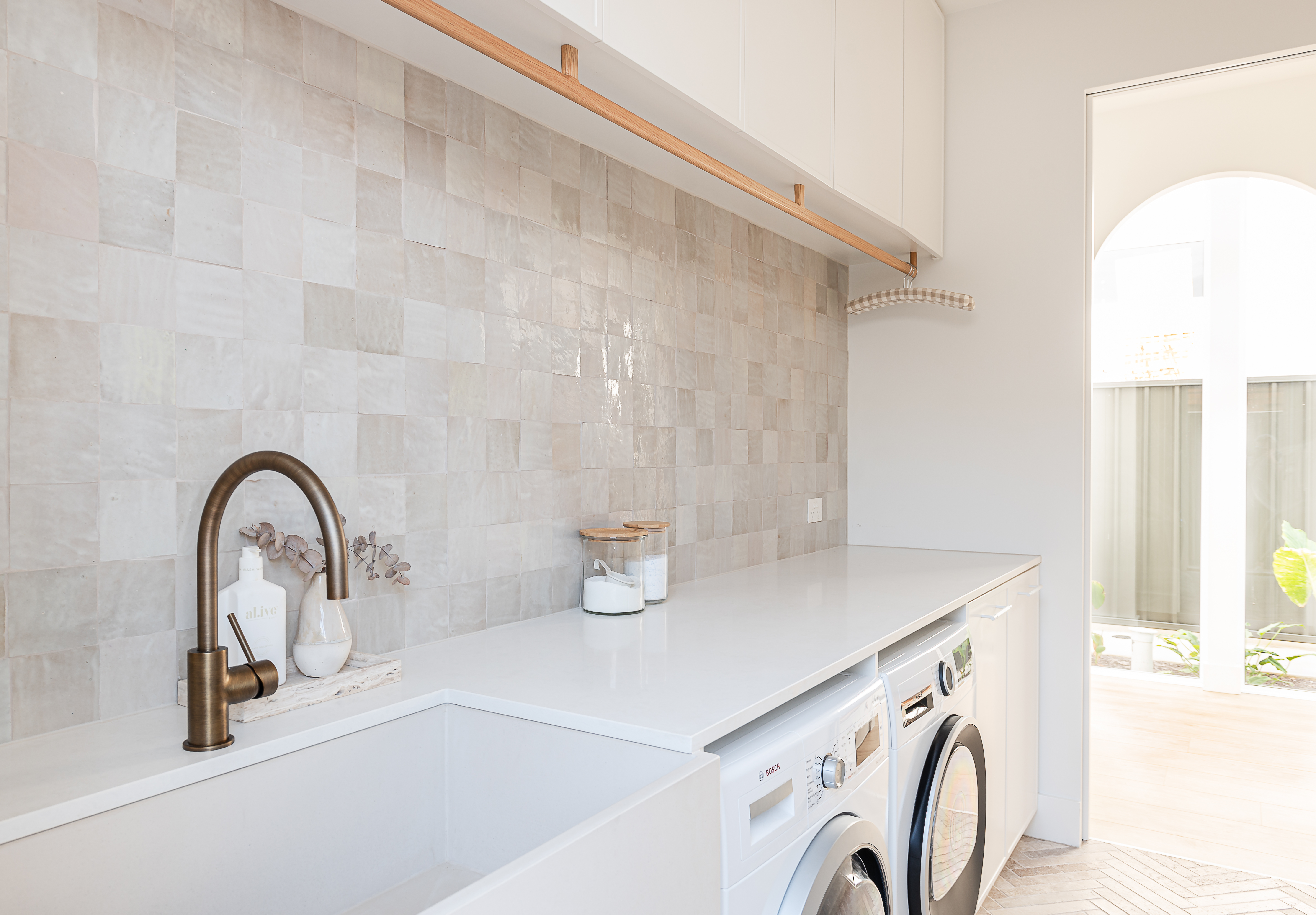 a white counter top laundry room with a sink and washing machine