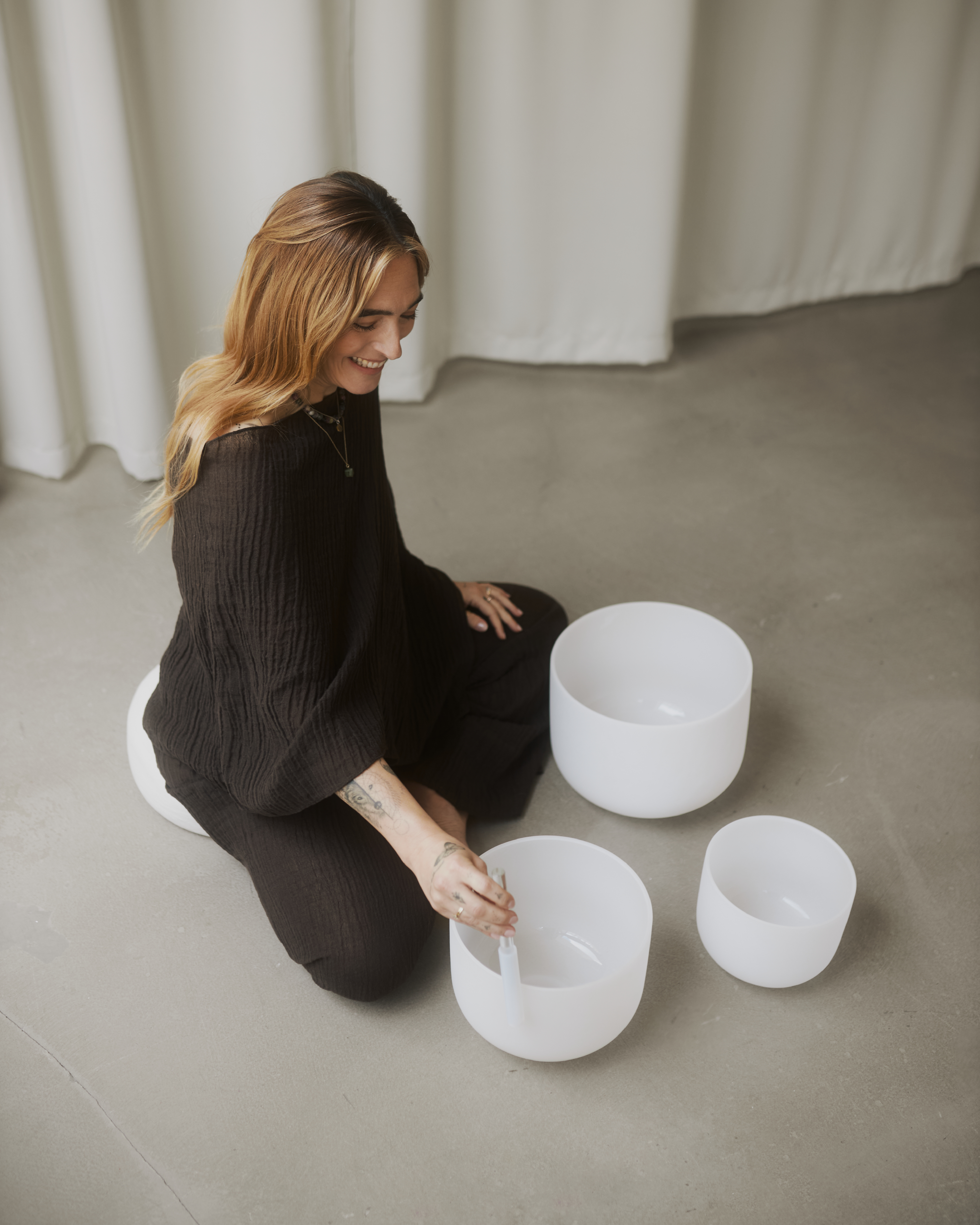 a woman sitting on the floor with white bowls
