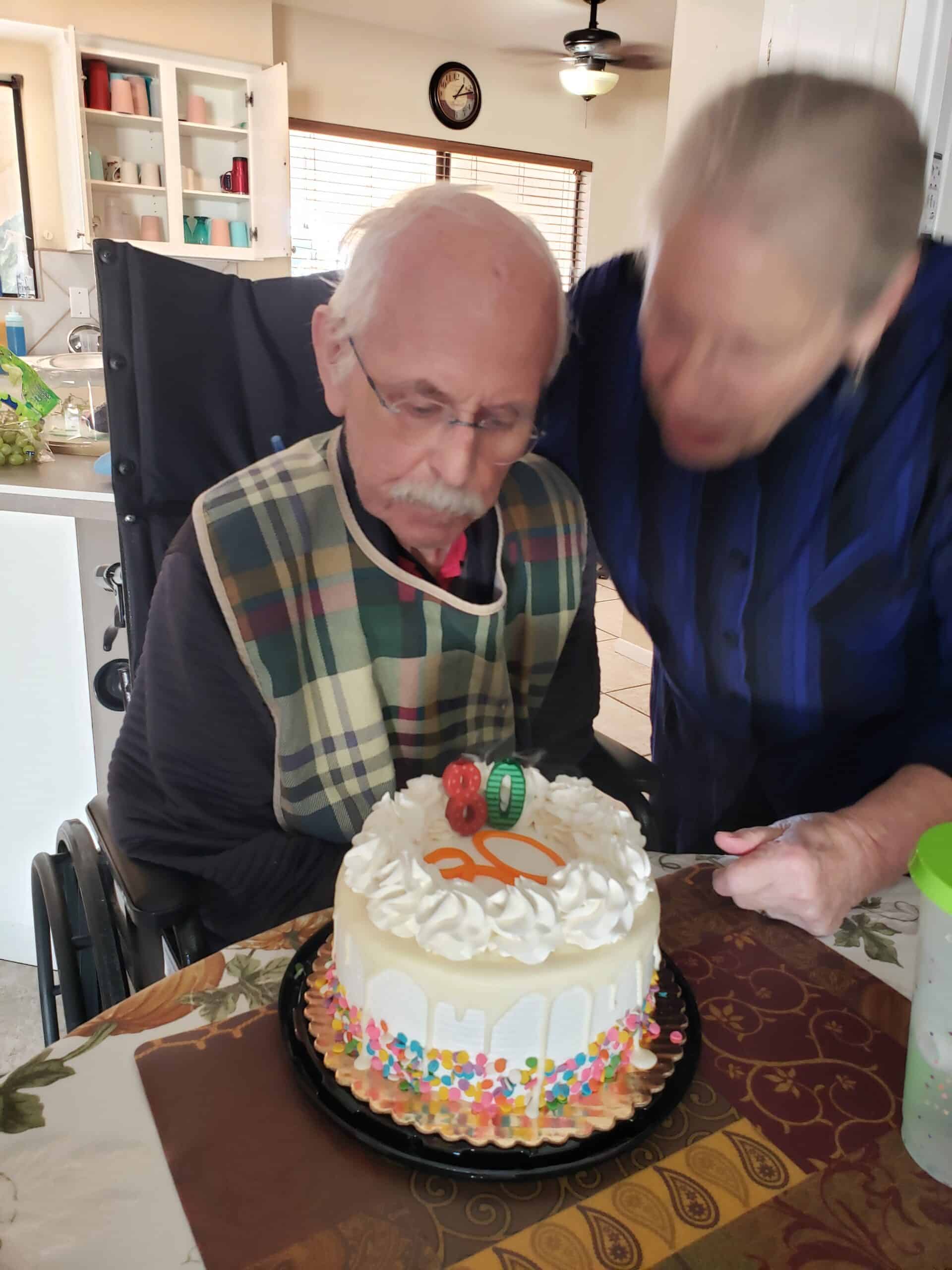 a man sitting in a chair with a cake