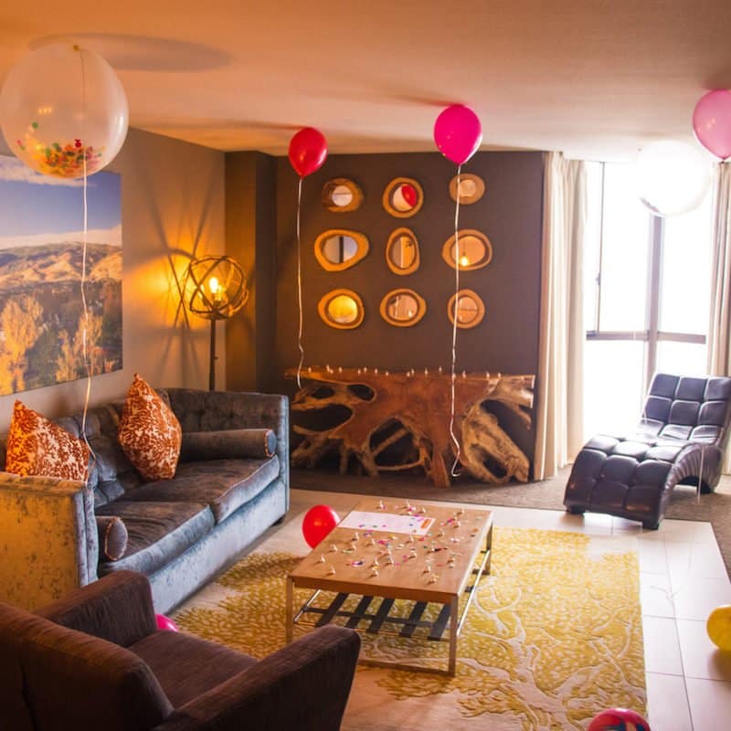 a living room with couches and balloons
