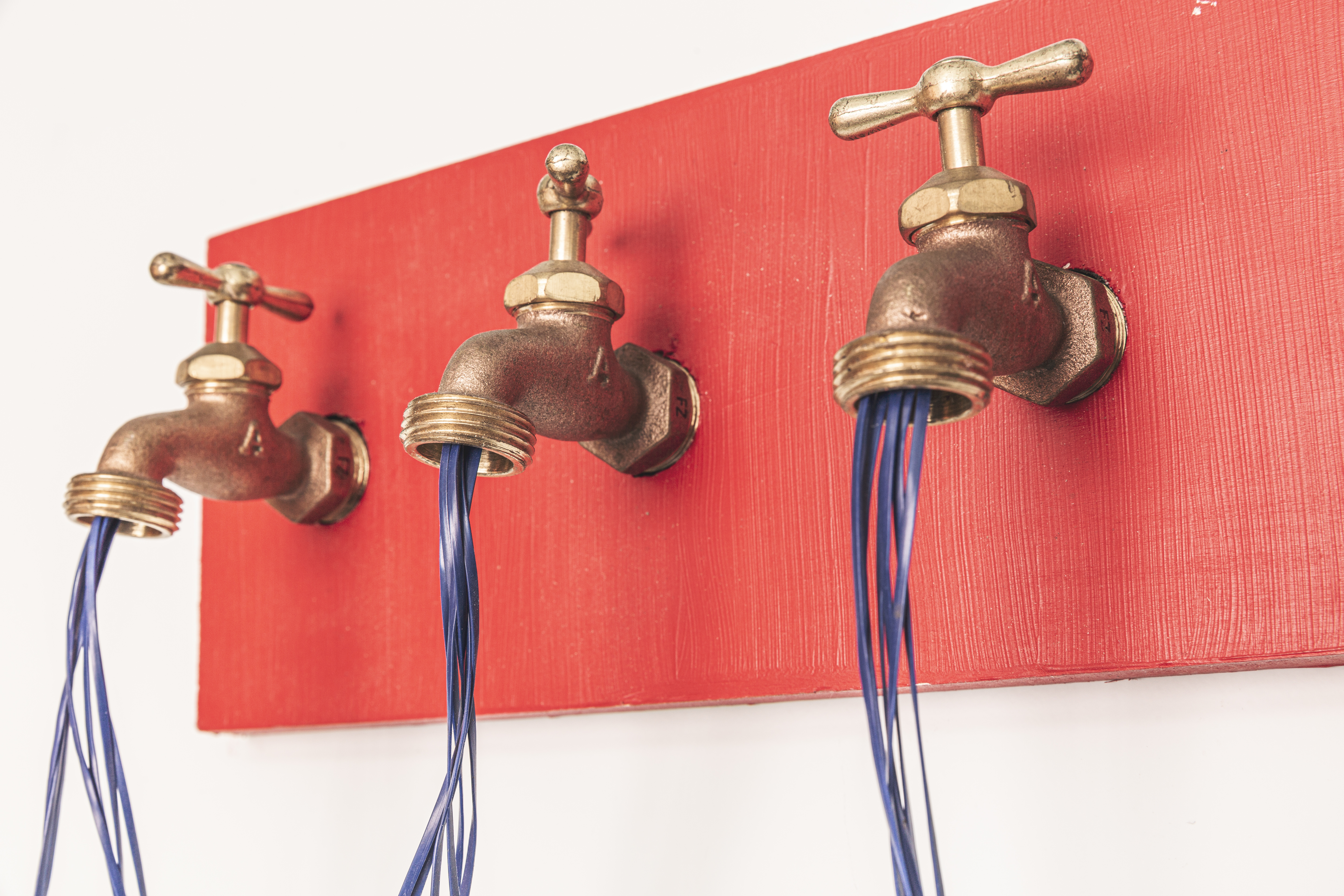 a group of faucets with blue and red wires coming out of them