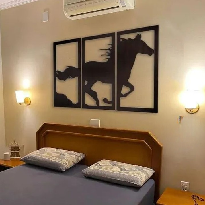 a bedroom with a bed and a horse artwork on the wall