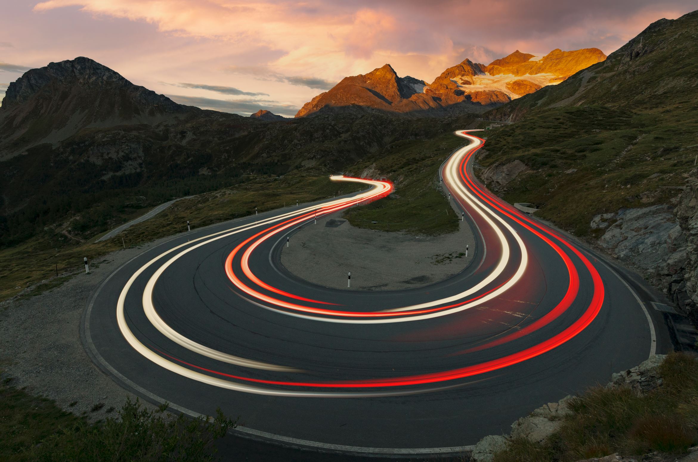 a winding road with red lights on it