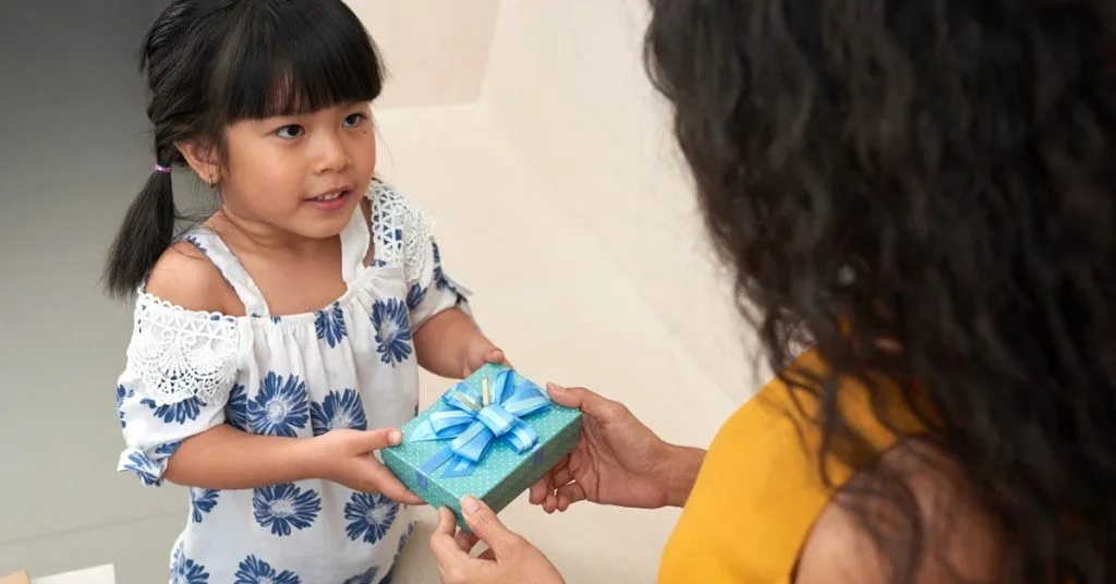 a girl receiving a present from a woman